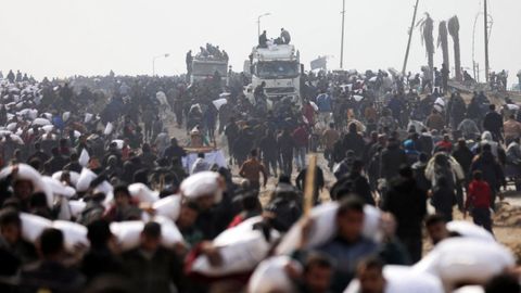 Varios gazates, con sacos de harina que consiguieron de un camin de ayuda humanitaria.