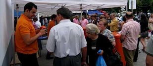 Un t�cnico explica a un usuario el empleo de los embudos para la recogida de aceites usados.