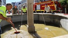 Labores de limpieza y de captura de los peces, ayer en fuente de la Praza de Galicia.