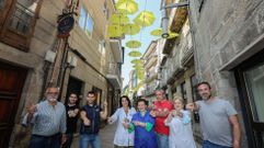 Los comerciantes de la calle Real con su gigantesca flecha amarilla hecha con paraguas.