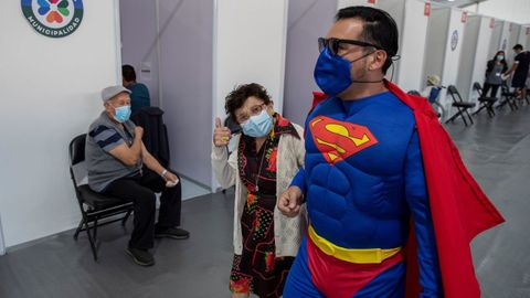 Un hombre vestido de Superman acompa�a a su madre a vacunarse en un centro de salud de Santiago de Chile
