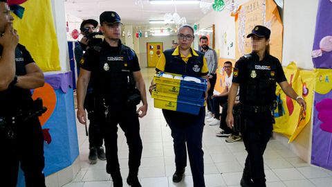 Agentes de polica escoltan a una trabajadora de Correos en un colegio electoral de Melilla