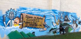 Mural en memoria de Manuel realizado por Cami (en la imagen, agachado delante de su obra)