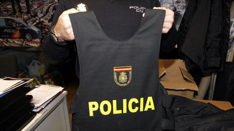 Foto de archivo de un agente mostrando un chaleco antibalas