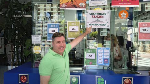 Santiago Fern�ndez posa junto al cartel que anuncia el premio vendido en la administraci�n lalinense.