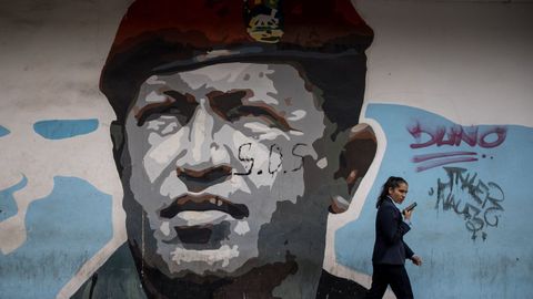Una mujer pasea frente a un grafiti de Hugo Chvez en Caracas.