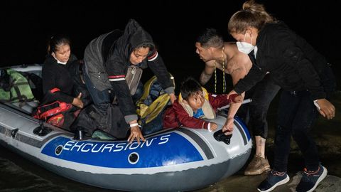 Inmigrantes desembarcan de un bote tras cruzar el río Grande a Texas desde México