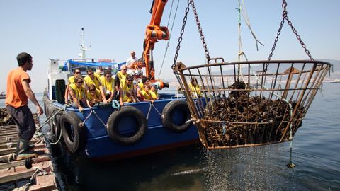 Un grupo de turistas a bordo de un barco mejillonero en la ra de Vigo.