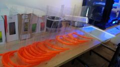 Un lote de viseras de acetato ya terminadas junto a la impresora en tres dimensiones que se est� utilizando para producirlas