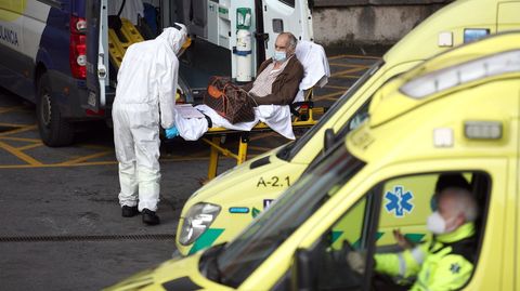 Un trabajador de ambulancias con los epis lleva a un paciente de covid al hospital vizcano de Cruces.