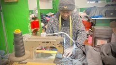 Moi Ndiaye arreglando la cremallera de la cazadora de una de sus clientas en su m�quina de coser.