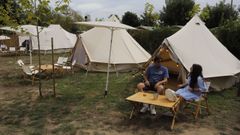 Un hombre mira por dentro la decoraci�n de la tiendas para gl�mping instaladas en Rianxo.