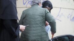 Una monja introduciendo el voto en un bolsillo a una persona mayor