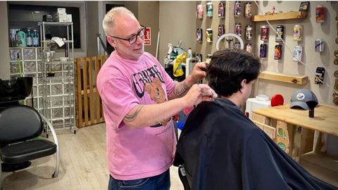 Roberto lvarez cortando el pelo a un cliente con peine y tijera y sin mquinas elctricas.