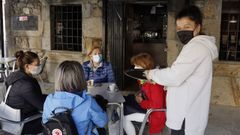 Mar�a Vilas� atiende a unas clientas en la terraza de su bar en el casco urbano de A Pobra