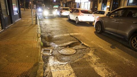 Hundimiento recurrente del asfalto en la calle Espa�oleto, junto al cruce con Vel�zquez, en torno a una alcantarilla y una tapa de registro.