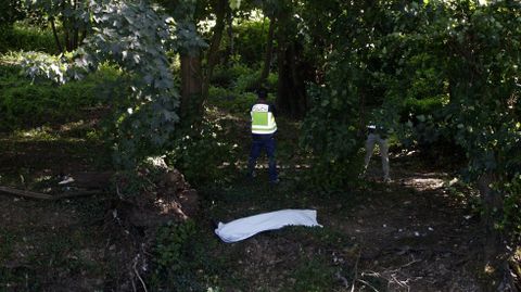 Un polica esta tarde junto al cuerpo sin vida del hombre que se ahog en el ro Cabe
