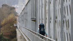 Una peregrina cruza el puente internacional de Tui-Valen�a.