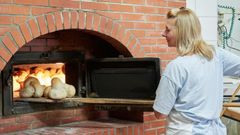 Nieves Gonz�lez, sacando del horno de le�a panes de trigo y de escanda