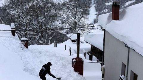 Vecinos de Pajares (Asturias) retiran nieve del tejado de su casa de 300 aos, una de las ms antiguas del pueblo.