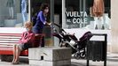  Una mujer camina frente a un escaparate con la campa�a de la vuelta al colegio en una calle del centro de Oviedo
