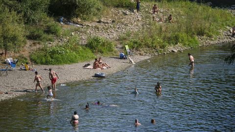 Ba�istas refresc�ndose en el agua esta tarde en el r�o Trubia, en Oviedo