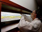 El cura de la iglesia muestra la ventana por donde accedieron los cacos al interior del edificio. 