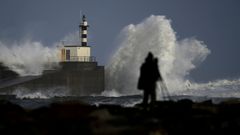Un hombre intenta sacar fotos del temporal en San Esteban de Pravia, Asturias.