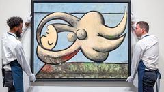 Fotograf�a cedida por Sotheby's donde aparecen dos de sus empleados mientras cuelgan la obra  Femme nue couch�e  (Mujer desnuda acostada)