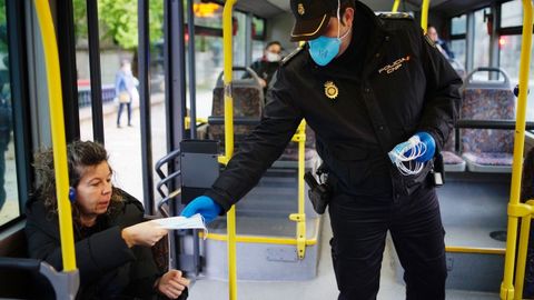 La Polica Nacional reparten mascarillas a usuarios del autobs en Ourense