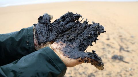 Chapapote arrastrado por la marea a la playa de Queiruga, en Porto do Son, el lunes.