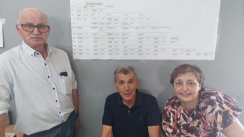 Antonio, Javier y María Peteiro, bajo el árbol genealógico que colgaron en una de las paredes del recinto ferial donde realizaron la comida.
