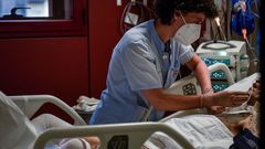 Una sanitaria atiende a un paciente ingresado en la uci del Hospital de Basurto en Bilbao