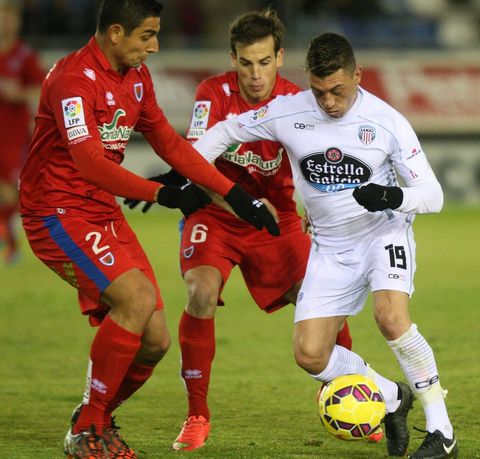 Jonathan Valle trata de abrirse camino entre dos jugadores del Numancia. 