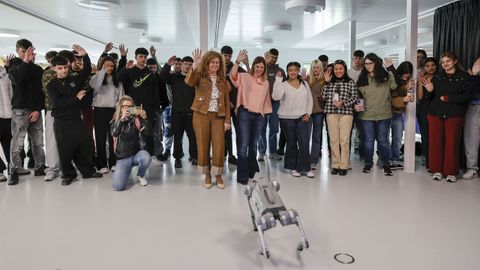 La directora xeral de FP, Eugenia P�rez, junto a Susana Carnero, directora del�CGIFP Eduardo Barreiros, saludan a un robot acompa�adas de alumnos.