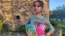 La ni�a Sara Corteguera Gonz�lez porta sus dos libros