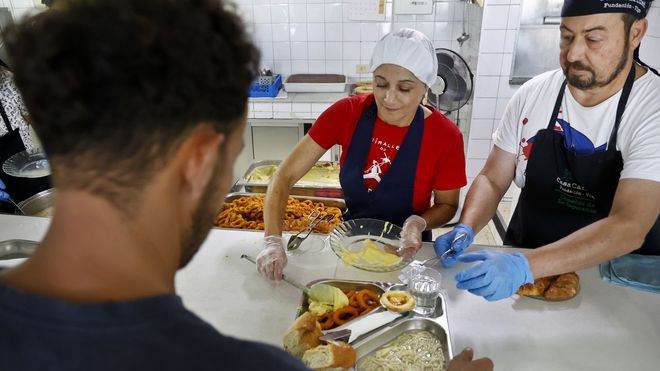 Voluntarios trabajando para dar de comer a los beneficiarios
