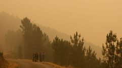 Unos vecinos, este sábado rodeados de humo en la carretera que da salida a Cereixido, Paradapiñol y Rugando hacia la N-120 y Quiroga
