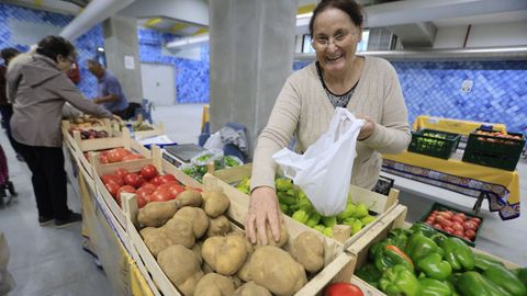 La presencia de patatas en lugares donde se venden productos agr&iacute;colas de proximidad es habitual en todo tipo de poblaciones (en la imagen, una vendedora en el mercado municipal de Lugo).