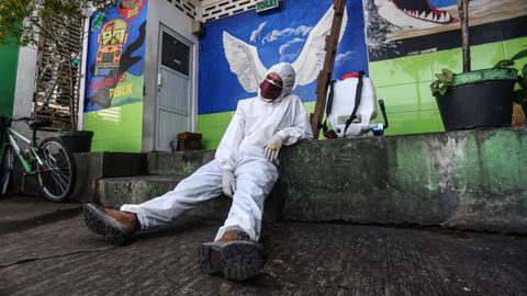 En Bandung, Indonesia, un operario con un traje protector se toma un respiro en las tareas de desinfeccin