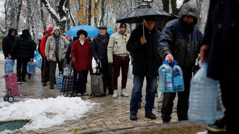 Residentes en Kiev hacen cola para coger agua tras los da�os sufridos por las infraestructuras por los ataques rusos