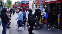 Gente sube y baja de un autob�s en el distrito londinense de Brixton 