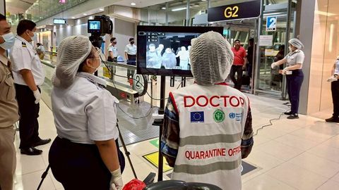 Las autoridades sanitarias aeroportuarias, con mascarillas protectoras, monitorean a los pasajeros de vuelos internacionales que llegan al aeropuerto de Bangkok tras la implementaci�n de medidas de control para los viajeros procedentes de la India. 
