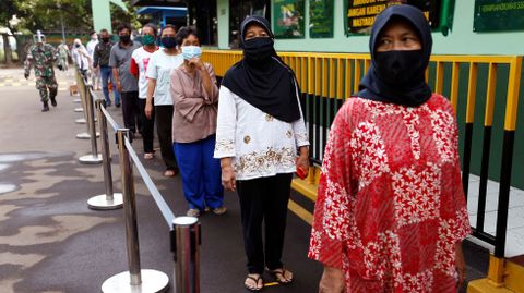 Mujeres hacen cola para recibir ayudas alimenticias en Jakarta, Indonesia
