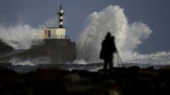Un c�mara toma im�genes de las olas estrell�ndose contra el puerto de San Esteban de Pravia