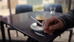 Una persona fuma en la terraza de un bar.