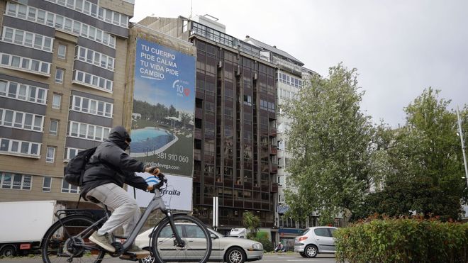 Al fondo, con fachada oscura, el edificio de la plaza de Ourense donde se encuentra el piso en venta más caro de A Coruña