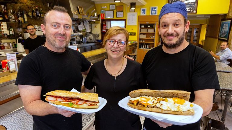 Montse Fernndez, duea del Dique 2, junto a sus cocineros, con un bocadillo de lomo completo y otro de raxo con patatas y huevos.