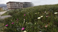 Edificio que nunca fue habitado y esqueleto de viviendas sin acabar, en A Atalaia