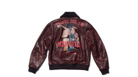 Cazadora aviador de cuero. Basada en una prenda del propio Bailey, esta chaqueta de aviador de cuero marrón lavado tiene un acabado envejecido. Incluye cuello de borreguillo, silueta de los años 40 y un gran estampado fotográfico en la espalda. El forro de seda lleva un dibujo del artista